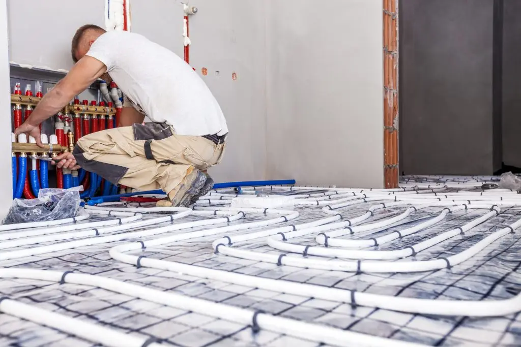 A worker installing underfloor heating system